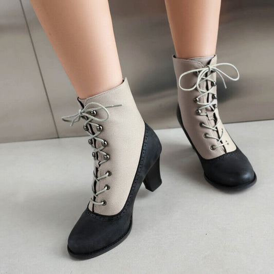Black and beige lace-up boots on a neutral background