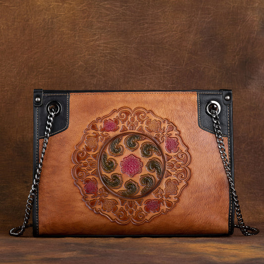 Brown leather handbag with intricate embossed design on a brown background