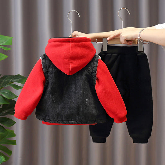 Children's outfit with red hoodie and black pants on hangers against a neutral background