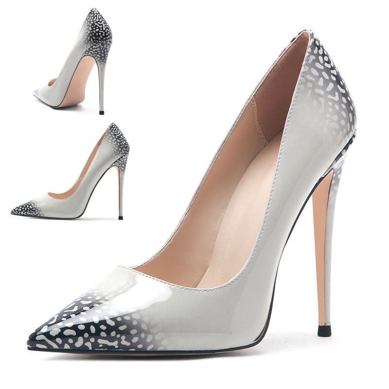 Silver high-heeled shoes with black and white patterned toe caps on a white background