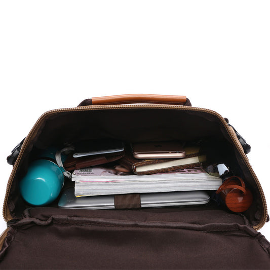 Brown leather bag with various items inside on a white background
