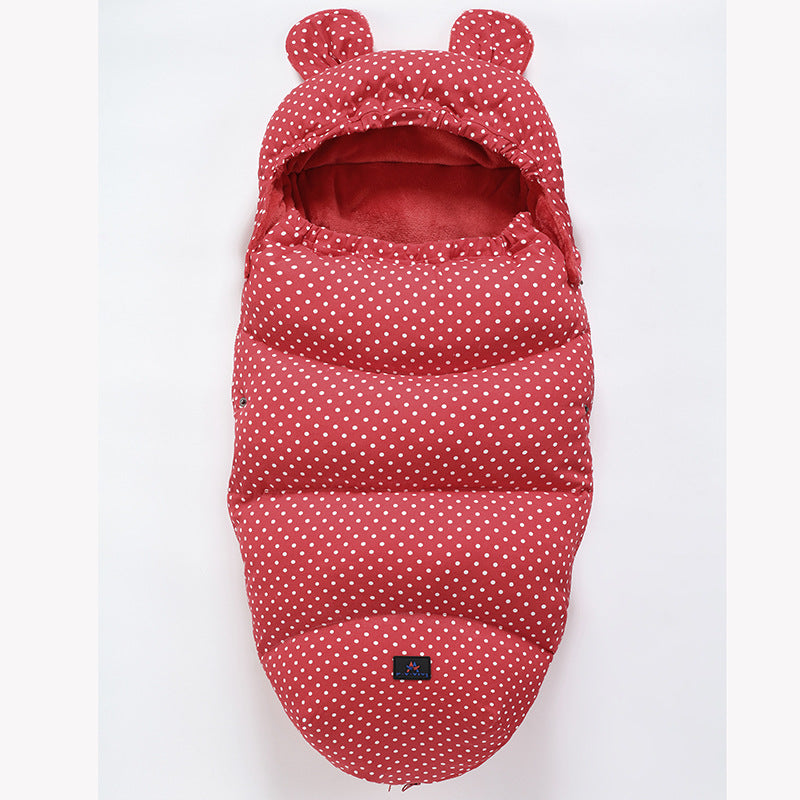 Red baby sleeping bag with white polka dots and bear ears on a light gray background