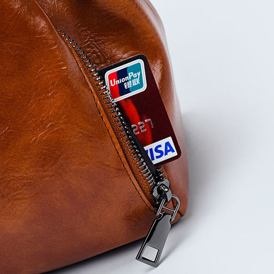 Brown leather pouch with a zipper featuring a Visa and UnionPay card inside.