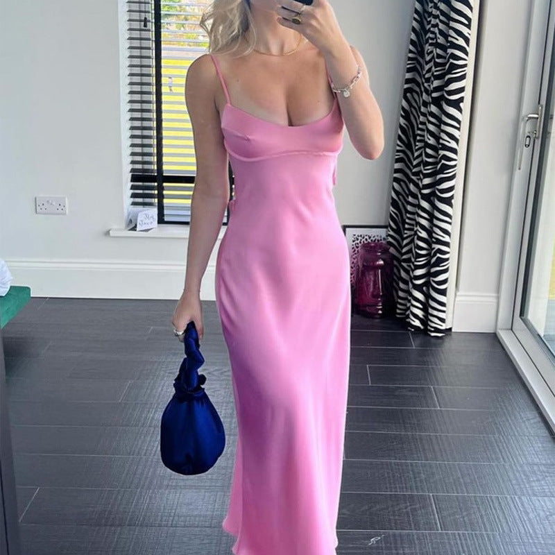 Woman in a pink dress holding a blue clutch in a room with a zebra print curtain.by millivan