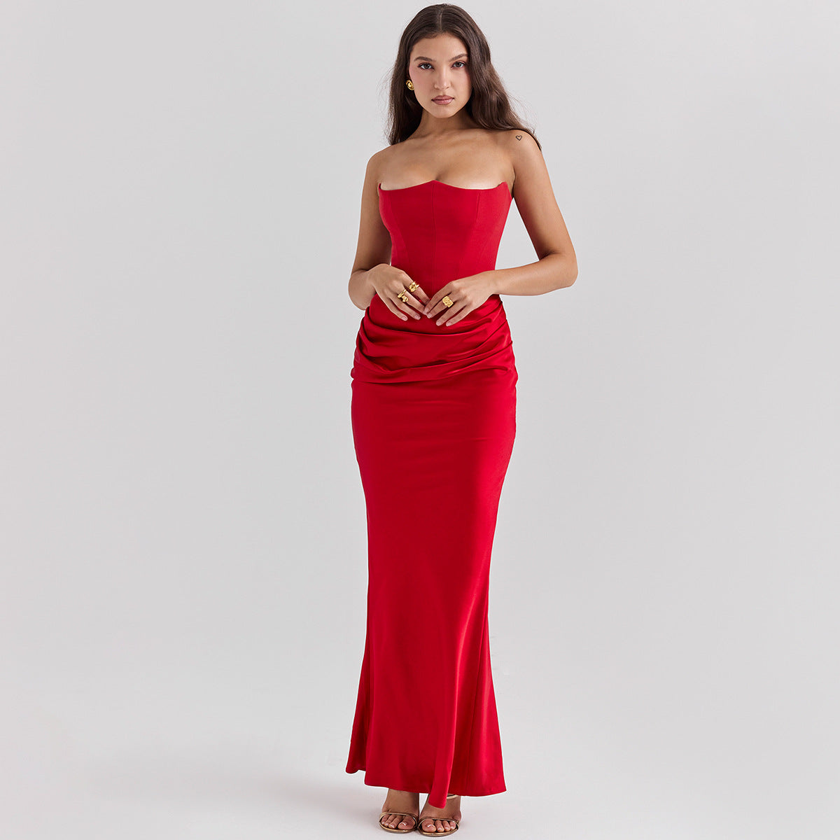 Woman wearing a strapless red dress on a light gray background