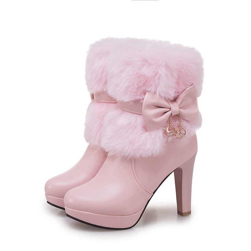 Pink high-heeled boots with fluffy fur and a bow on a white background