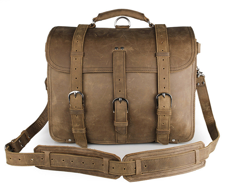Brown leather satchel bag with straps on a white background