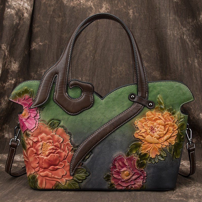 Floral-patterned handbag with a brown handle on a textured brown background