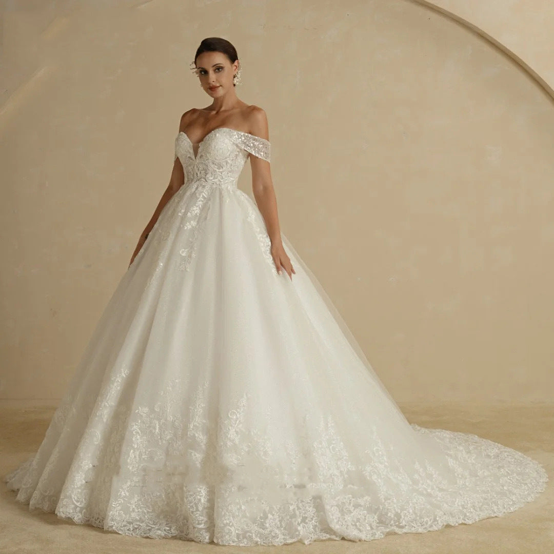 Woman wearing a white lace wedding dress against a beige background