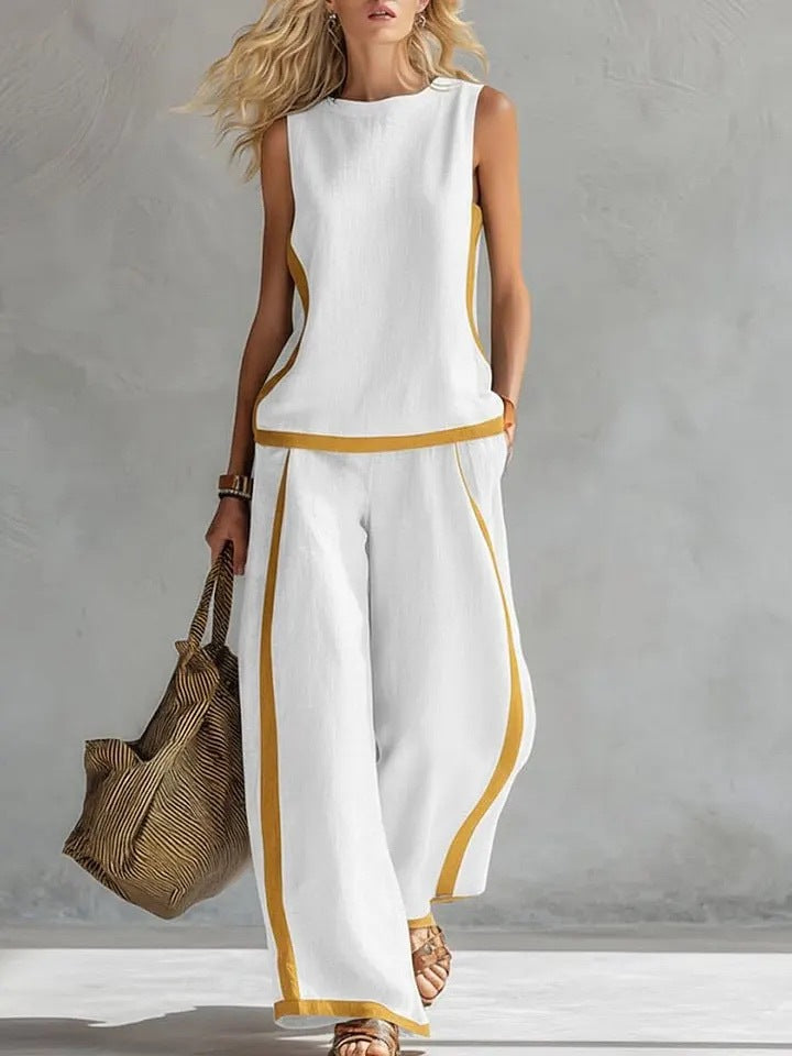 Woman wearing a white outfit with gold trim against a gray background