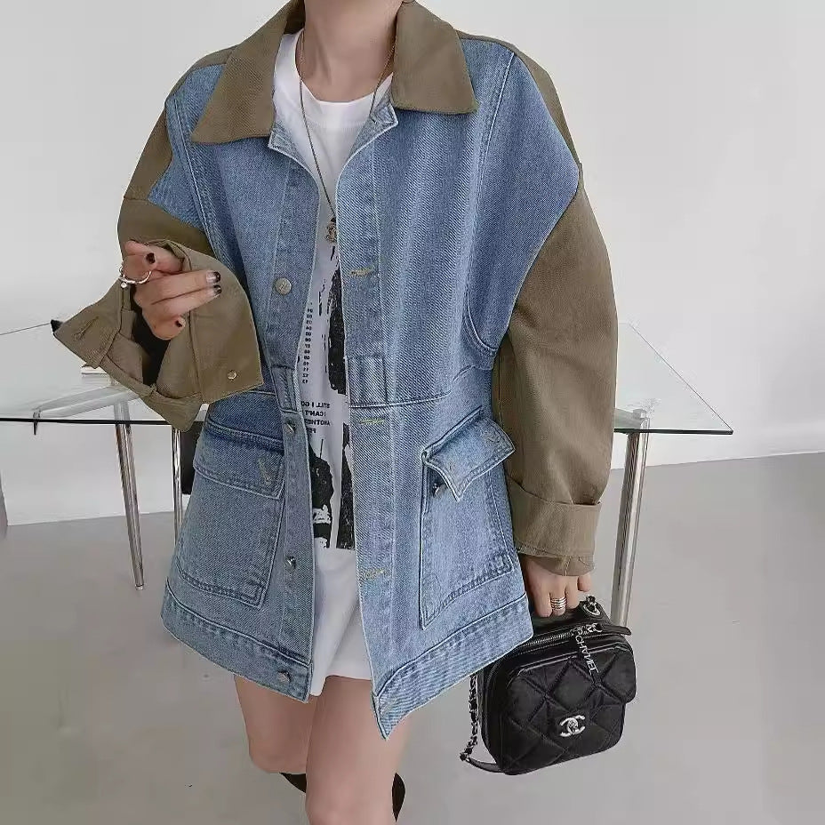 Person wearing a denim vest over a white shirt with a black handbag in a minimalistic setting