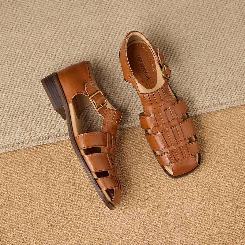 Pair of brown sandals with woven design on a beige textured background