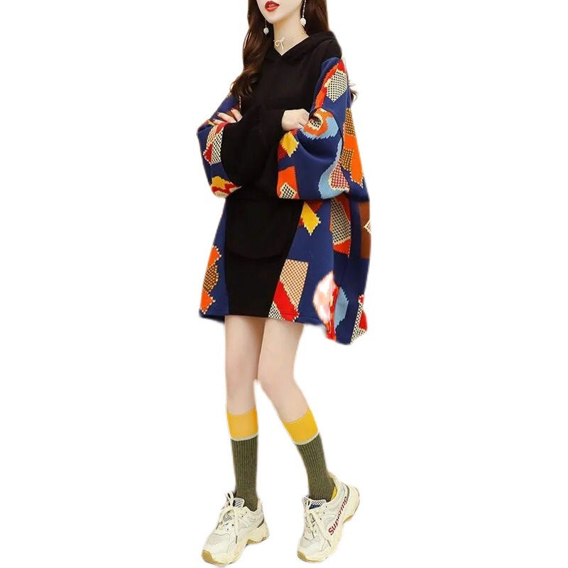 Person wearing a colorful patterned sweater over a black outfit on a white background