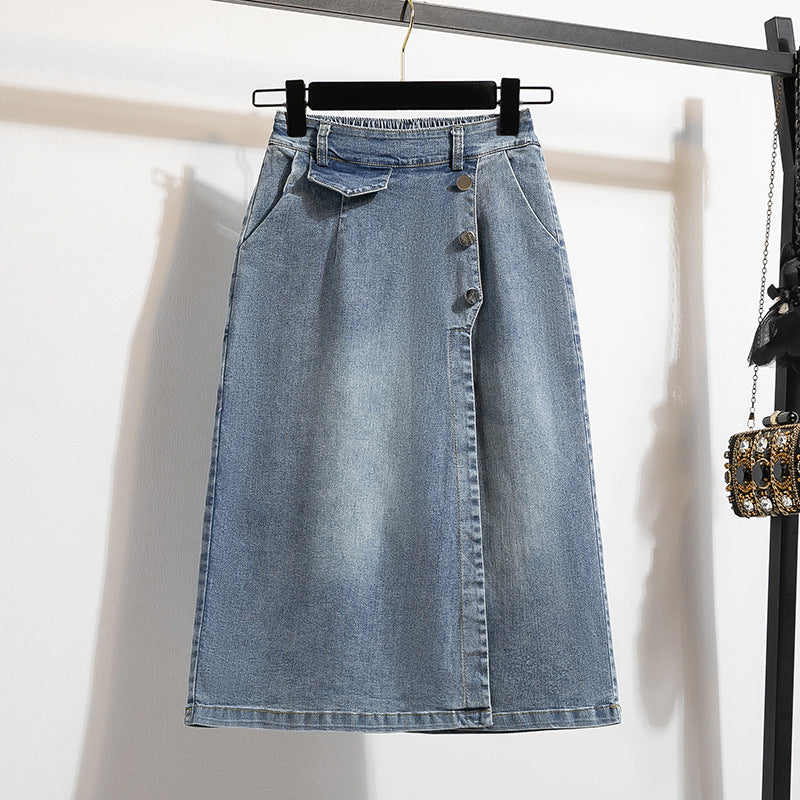 Blue denim skirt on a hanger against a white wall