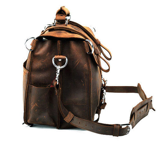 Brown leather backpack with metal hardware on a white background