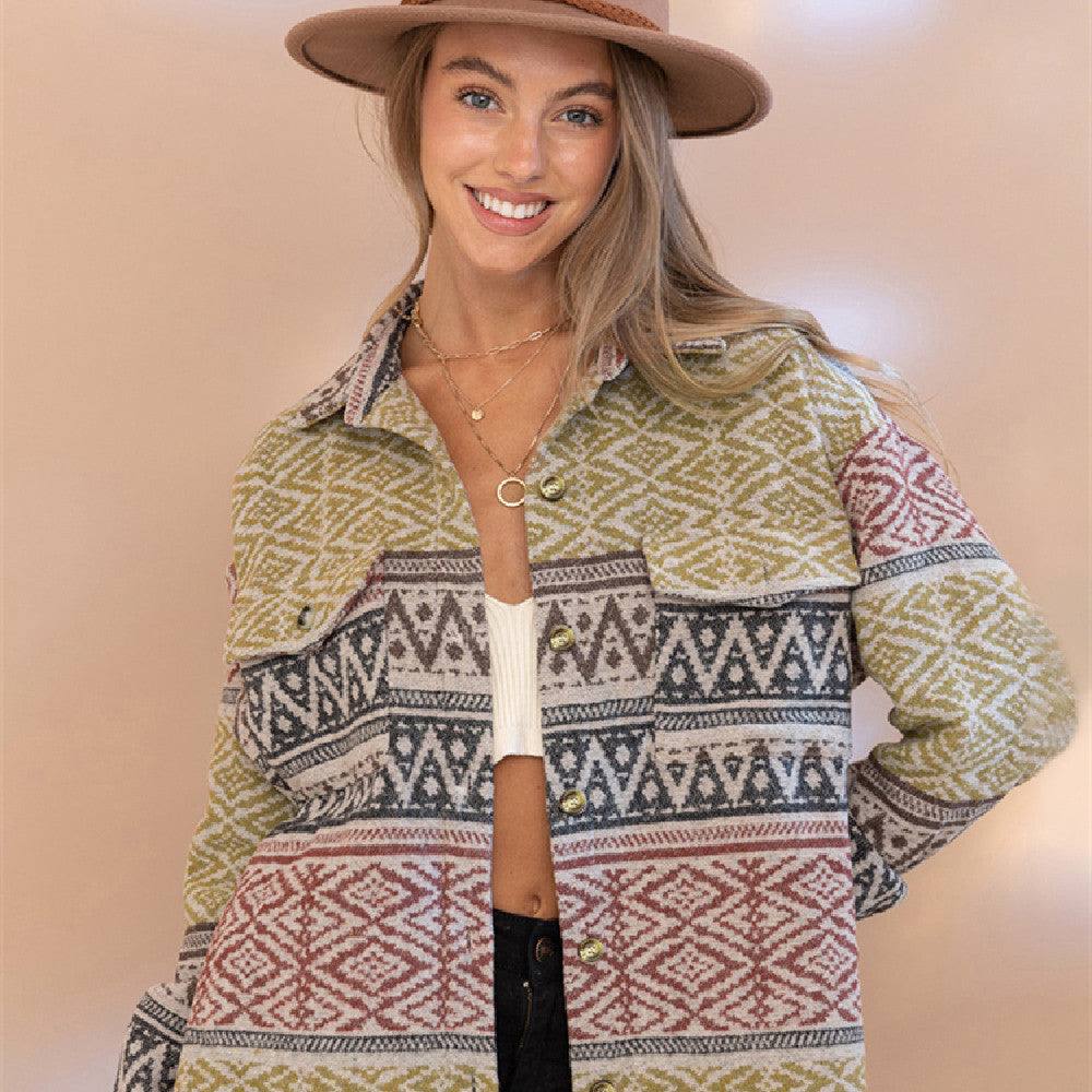 Woman wearing a patterned shirt and hat against a plain background