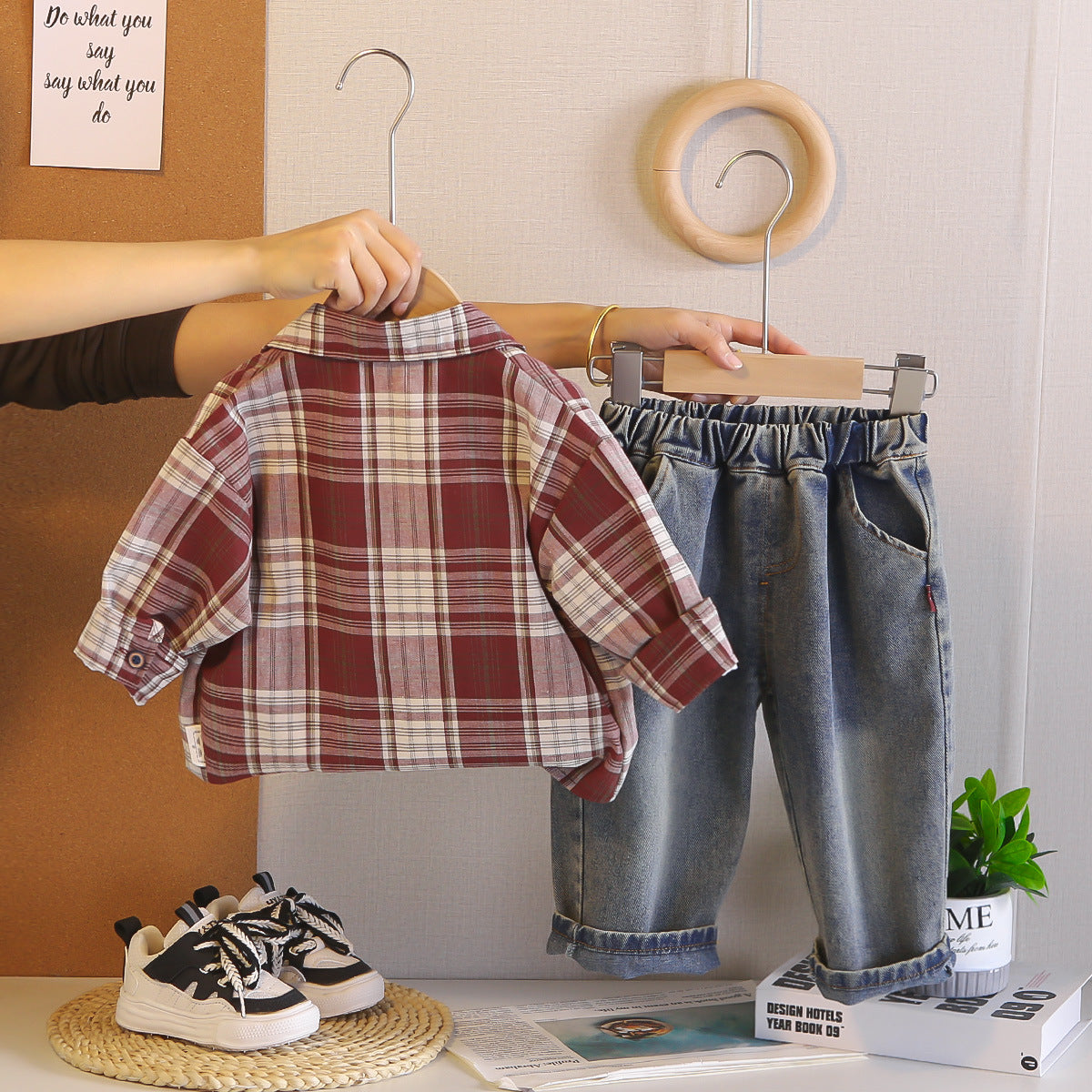 Plaid shirt and jeans on hangers with sneakers on the floor.