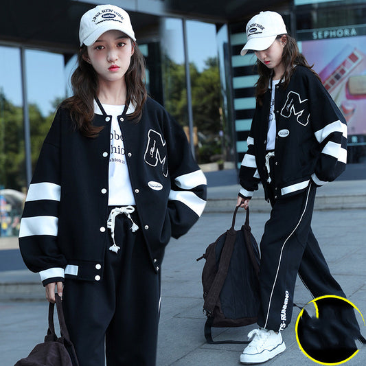Two people wearing matching black and white outfits with a focus on the pants in the foreground.