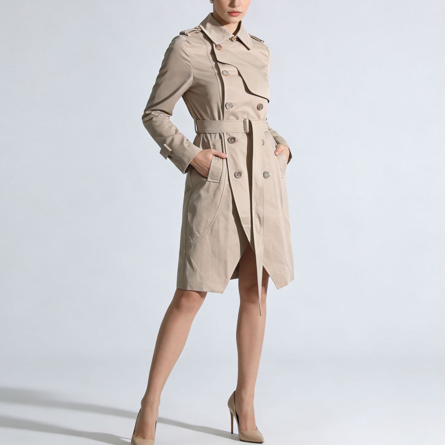Woman wearing a beige trench coat on a light gray background by millivan