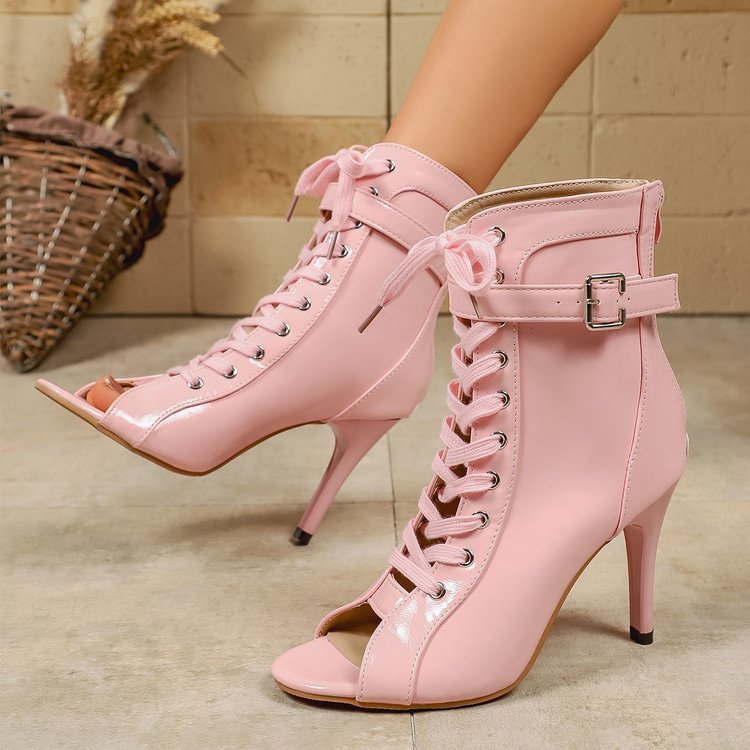 Pink high-heeled lace-up boots on a neutral background