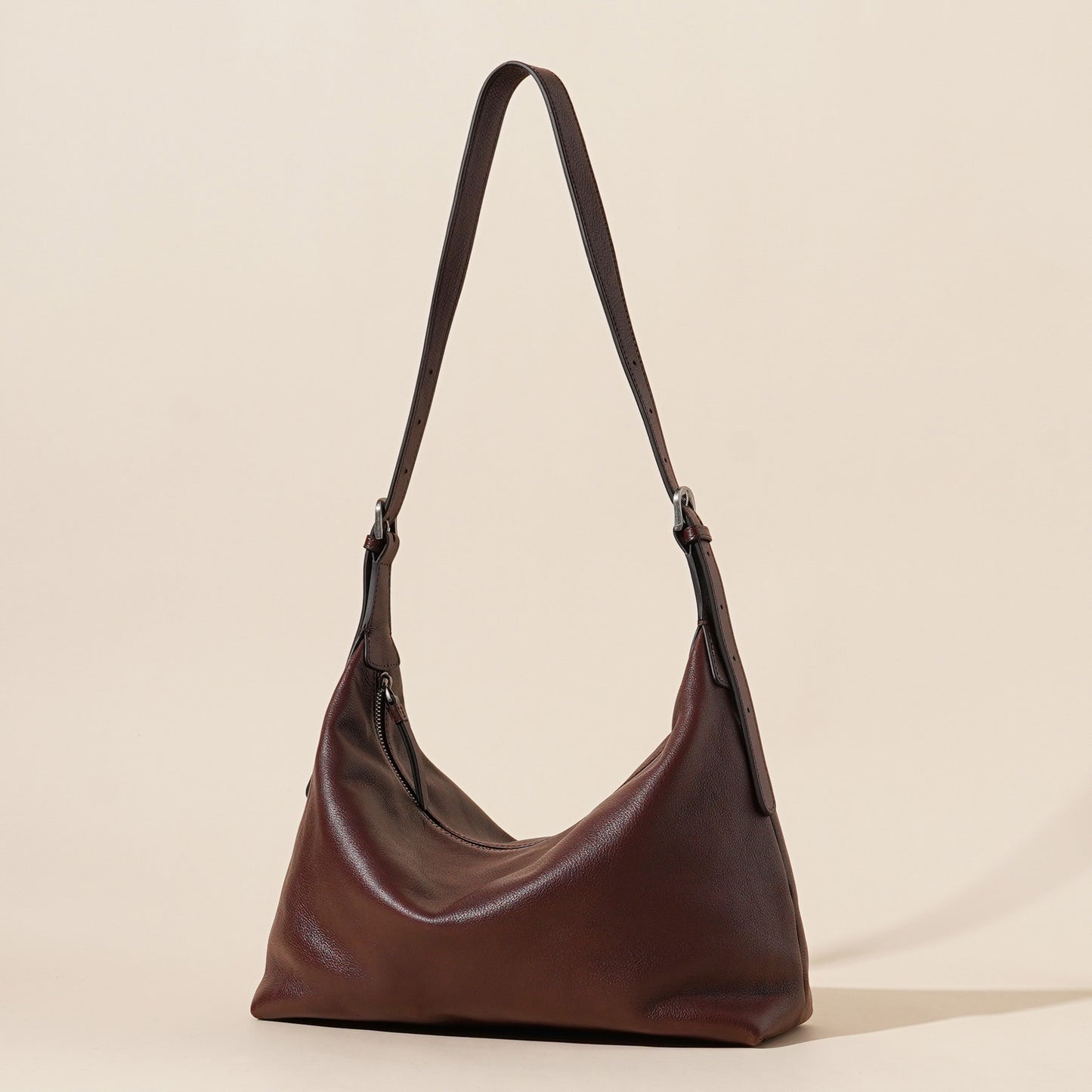Brown leather handbag on a beige background
