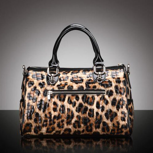 Leopard print handbag with black handles on a gray background