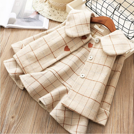 Beige plaid shirt with heart patterns on a wooden surface