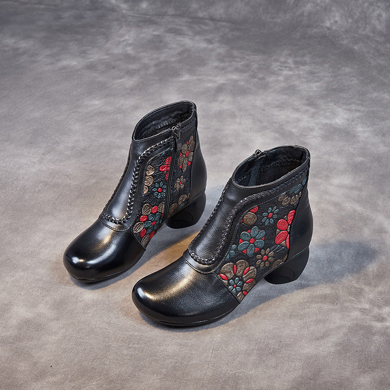 Black ankle boots with floral embroidery on a gray surface