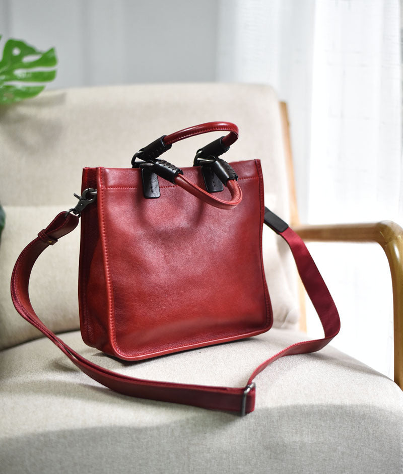 Red leather handbag on a light-colored sofa with a neutral background