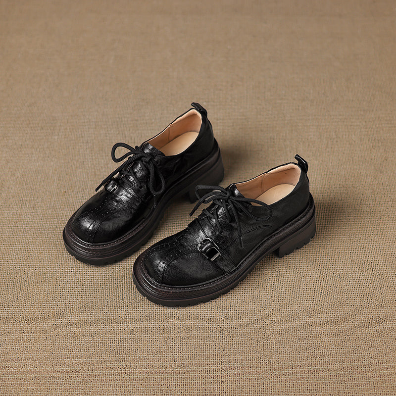 Pair of black leather shoes on a brown textured background