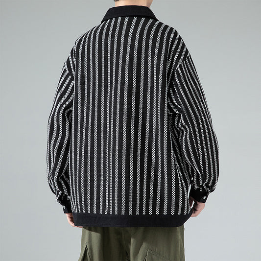 Person wearing a black and white striped shirt with a gray background