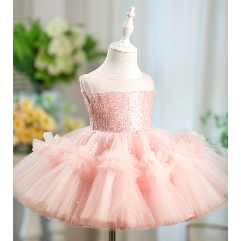 Pink sequin dress on a mannequin with a blurred floral background