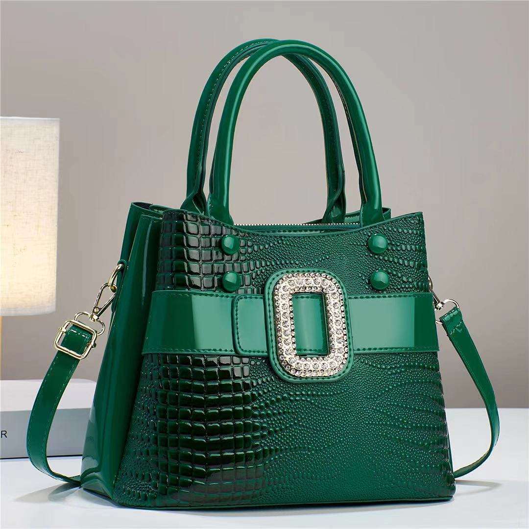 Green handbag with a decorative buckle on a neutral background