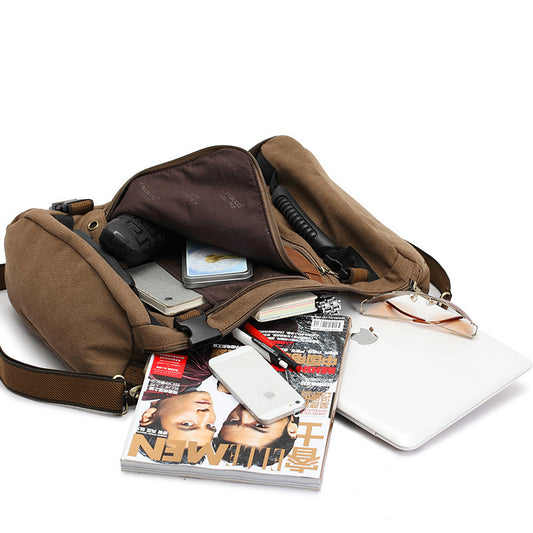 Brown crossbody bag with items including a magazine, phone, and laptop on a white background