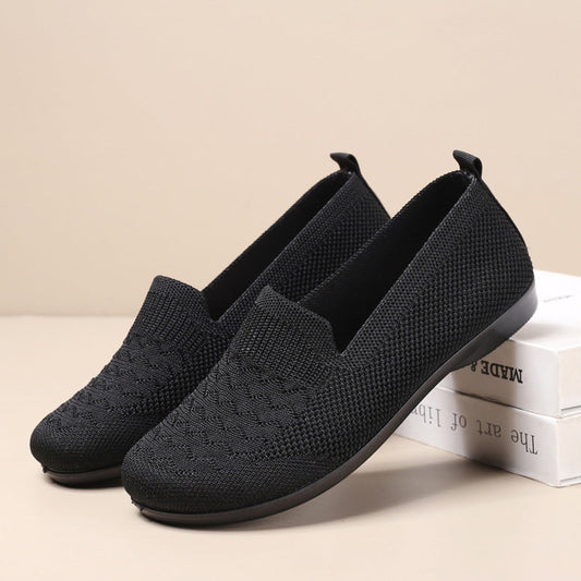 Black loafers on a beige background