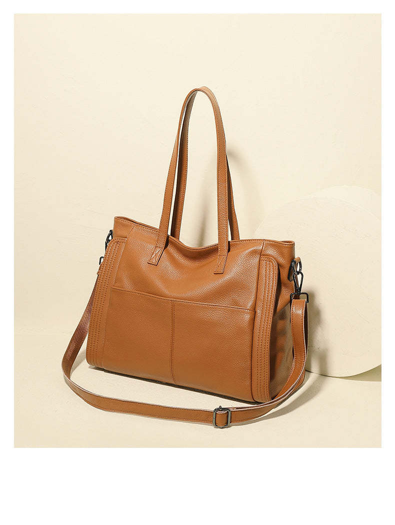 Brown leather tote bag on a beige background