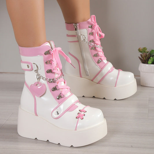 White and pink platform boots with decorative elements on a neutral background