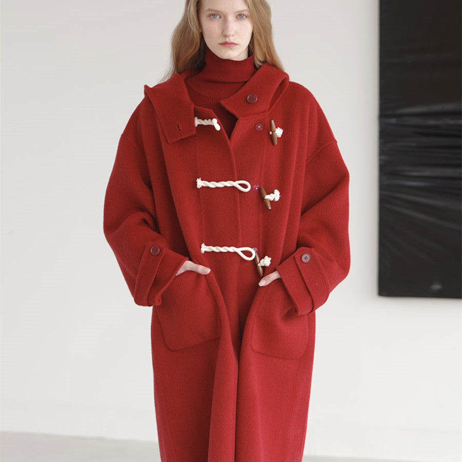 Red coat with white buttons worn by a model against a plain background