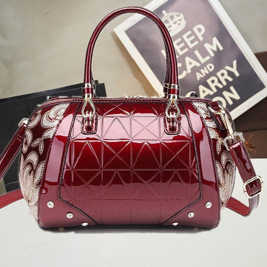 Red quilted handbag with decorative strap on a neutral background