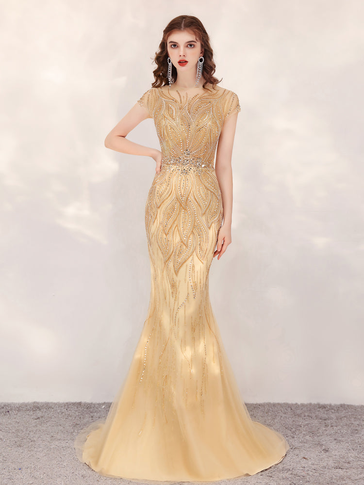 Gold evening gown with intricate design on a plain background