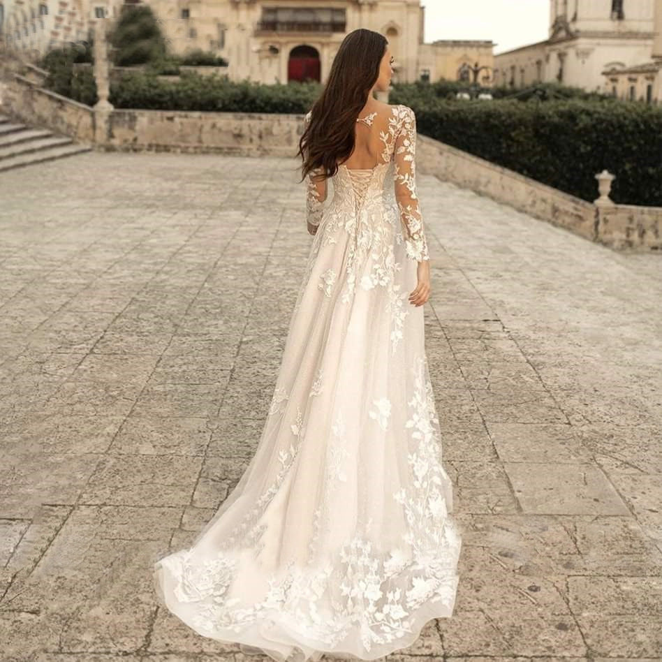 Woman in a white floral dress walking on a stone path with classical architecture in the background
