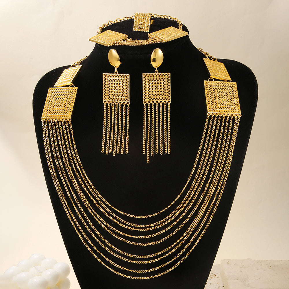 Gold necklace and earrings set on a black stand with a light background