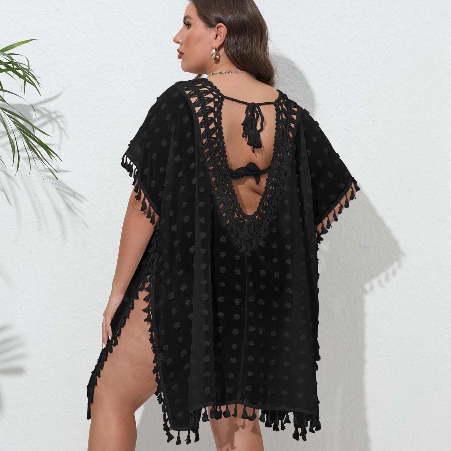 Woman wearing a black lace cover-up against a white background