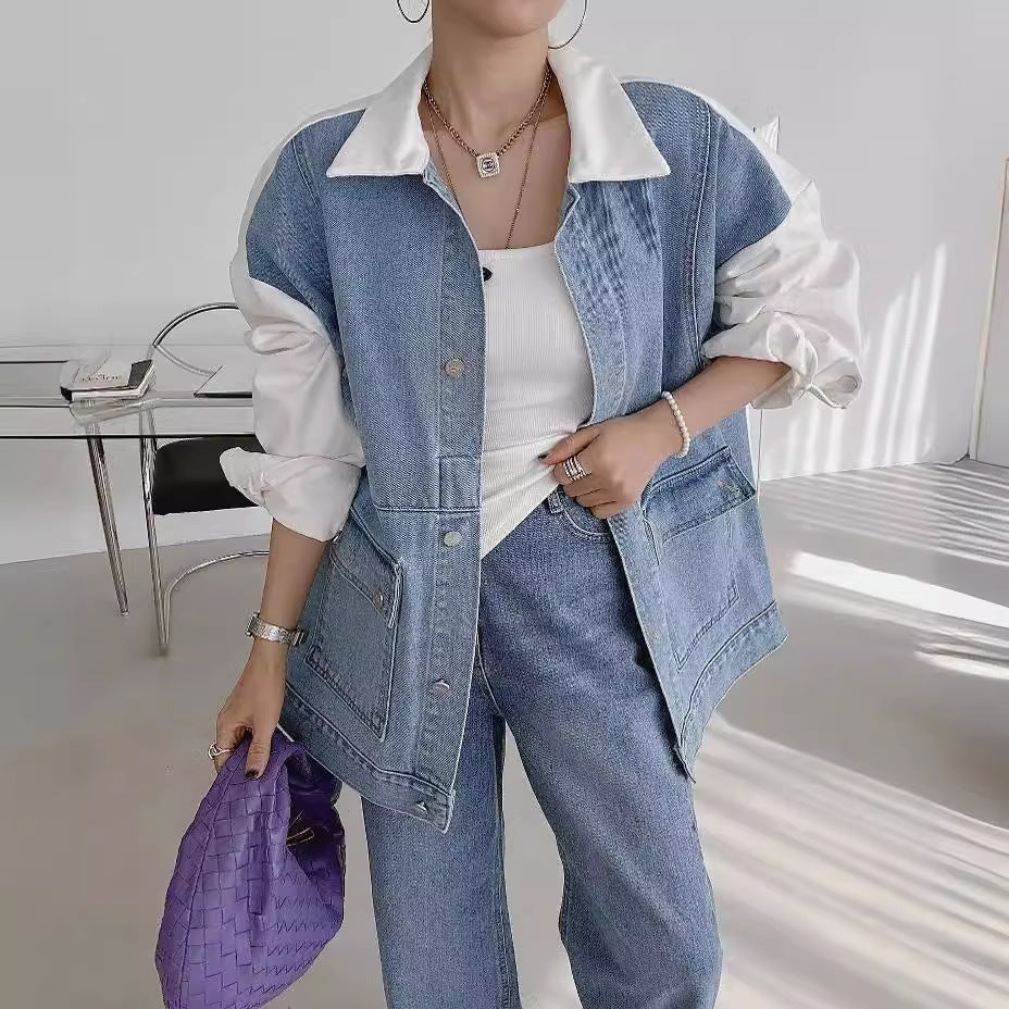 Person wearing a denim outfit with a white shirt in a minimalistic room.