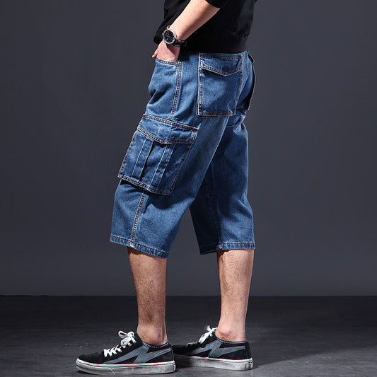Person wearing blue denim cargo shorts on a dark background