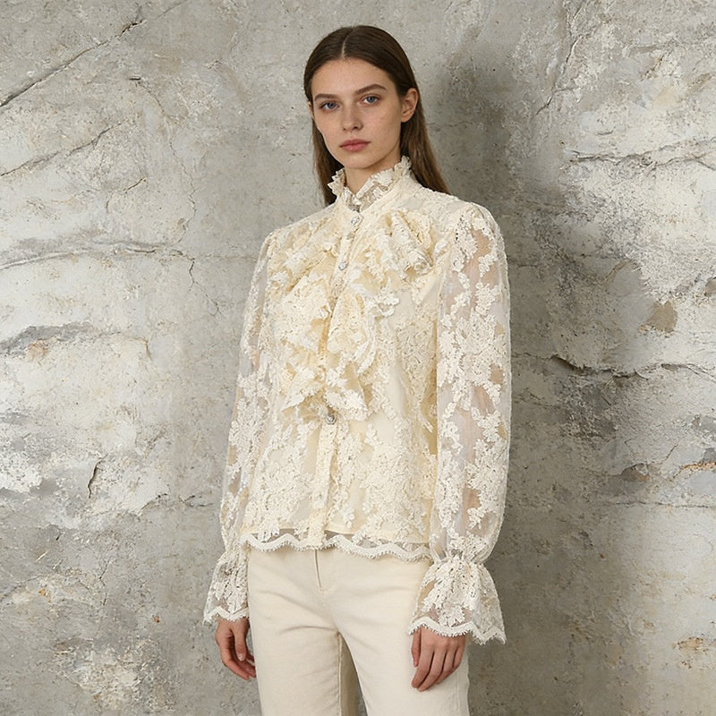 Woman wearing a lace blouse against a textured stone wall