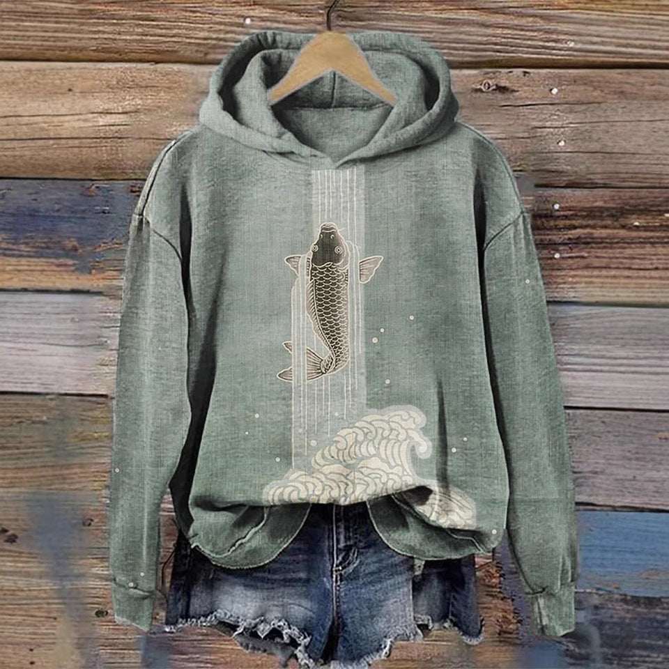 Green hoodie with fish graphic on a wooden background
