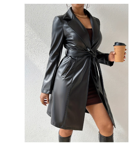 Person wearing a black leather coat holding a coffee cup against a neutral background