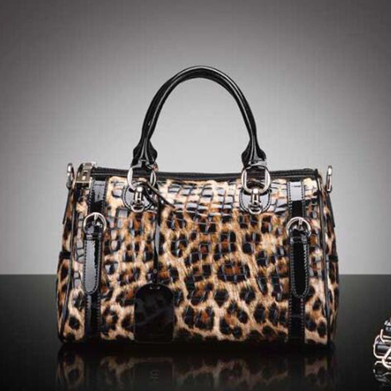 Leopard print handbag with black handles on a gray background