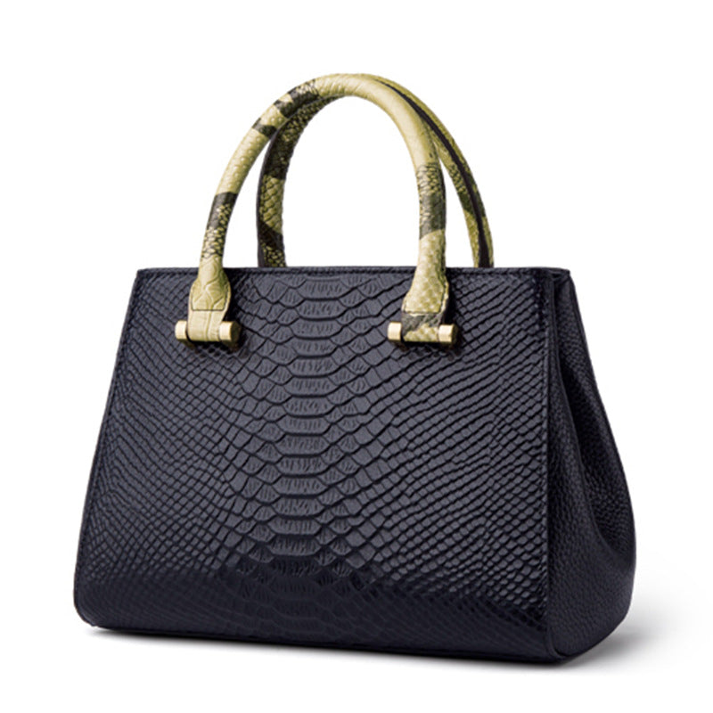 Black textured handbag with gold handles on a white background